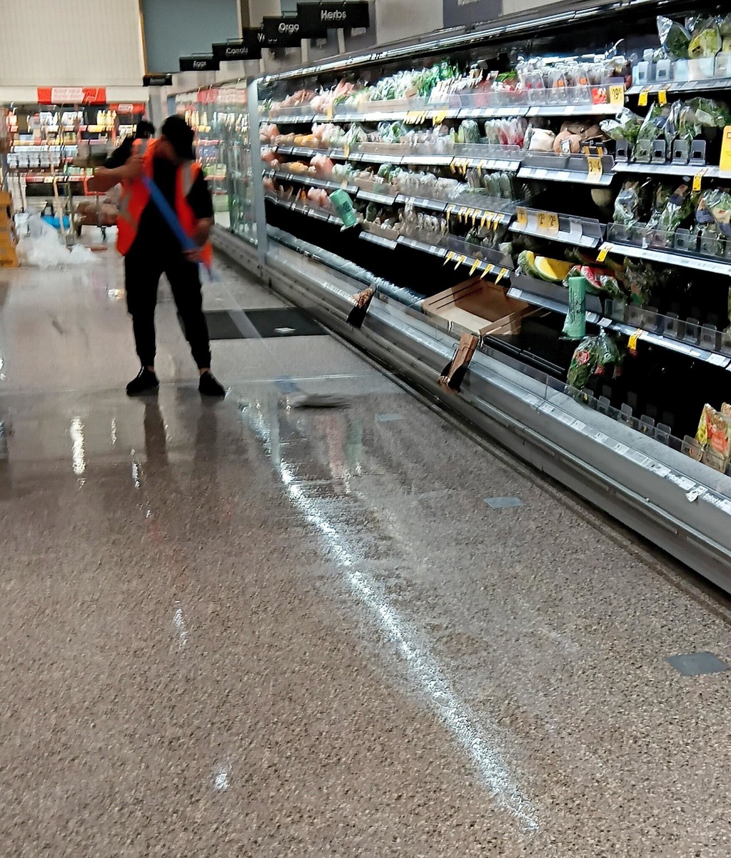 Team member ensuring any standing water is removed, before moving onto the next row of refrigeration units