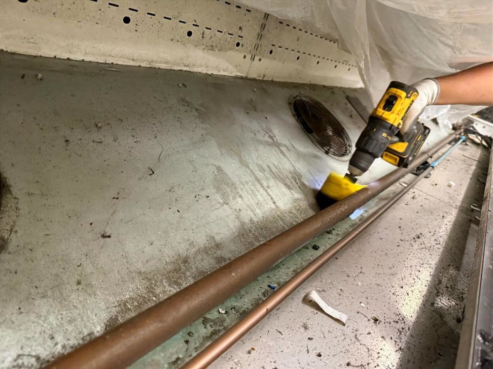 Team member maintaining a supermarket refrigeration unit